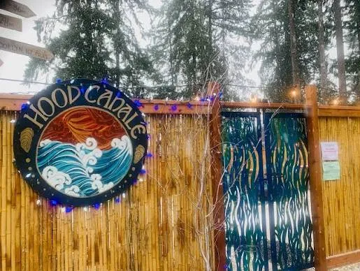 Hand-painted wave sign and string lights at the entrance to Hood Canale wood-fired pizza in Union, WA